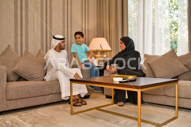 مفهوم النقاش والحوار بين الأهل، التعاون العائلي في إتخاذ القرارات الصائبه، أسره عربيه خليجيه اماراتيه تتبادل الأحاديث في غرفه الجلوس، عائله سعوديه تستمتع بقضاء أوقات الفراغ معا، ايماءات تدل على الألفه والحنان، تدعيم أواصر المحبه والترابط الأسري.