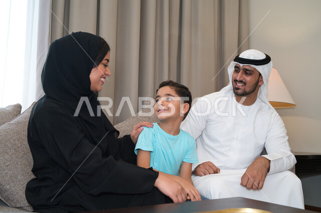 بر الوالدين وإظهار الاحترام والتقدير لهم، ايماءات تدل على الفرح والسعاده، عائله عربيه خليجيه اماراتيه تستمتع بالتسامر والضحك ، اسره سعوديه تجلس في غرفه المعيشه، مفهوم الترابط والتواصل بين الأباء والأبناء، تبادل الأحاديث والحوارات العائليه.