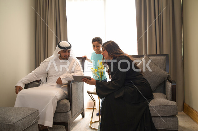 مشاهدة المسلسلات الممتعه عبر جهاز التابلت، متابعه مواقع التواصل الاجتماعي، عائله عربيه خليجيه اماراتيه تجلس في غرفه المعيشه، أسرة سعوديه تقوم بقضاء أوقات مليئه بالحب والموده، استخدام الأجهزة الالكترونيه والتقنيات الحديثه، طلب المنتجات والتسوق الالكتروني.