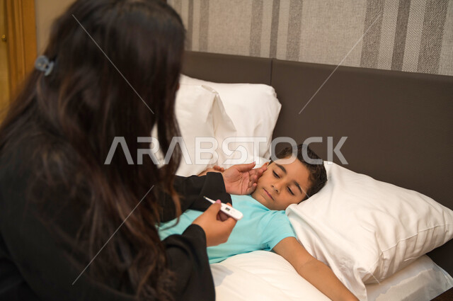 شعور الشخص المصاب بالإرهاق وأهمية العناية به, مراقبة ارتفاع درجة الحرارة لدى الأطفال وطلب المساعدة الطبية وقت الحاجة, صورة مقربة لولد عربي خليجي إماراتي مصاب بالحمى, أم سعودية تقوم بقياس حرارة ابنها المريض بواسطة جهاز ترمومتر
