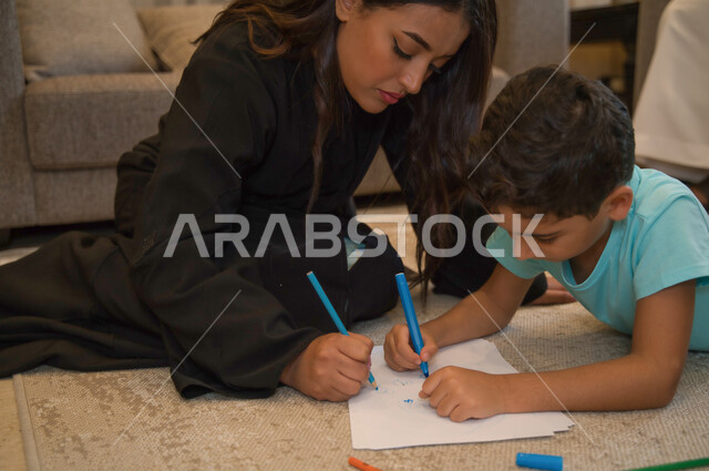 مشاركه الأولاد الأنشطه التعليميه المفيده، تنمية المهارات الفكريه والذهنيه لدى الأطفال، أم عربيه خليجيه إماراتيه تقوم بالرسم والتلوين مع ابنها، مفهوم العائله السعوديه المترابطه، الرعايه والإهتمام بتربيه وتعليم الأبناء، قضاء أوقات ممتعه في المنزل.