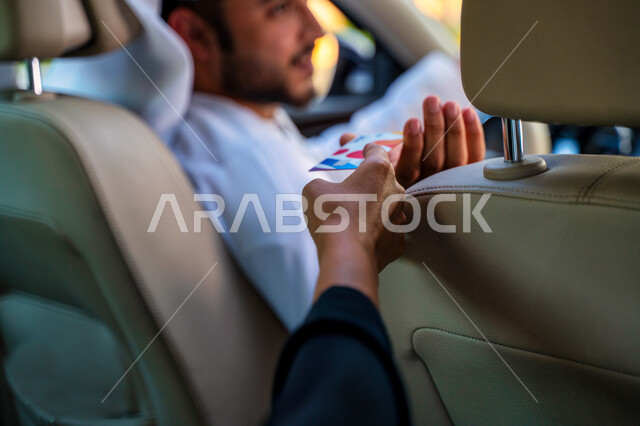 الدفع عن طريق بطاقة الإئتمان البنكية، القيادة بحذر والحفاظ على الامن والسلامة، رجل عربي خليجي إماراتي يقوم بإيصال الراكبة إلى وجهتها المطلوبة، التنزه في شوارع مدينة دبي، سائق سعودي يعمل على سيارة تاكسي، خدمة توصيل الركاب، خدمات النقل الآمنة