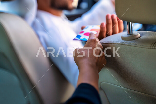 خدمة توصيل الركاب، الدفع عن طريق بطاقة الإئتمان البنكية، القيادة بحذر والحفاظ على الامن والسلامة، رجل عربي خليجي إماراتي يقوم بإيصال الراكبة إلى وجهتها المطلوبة، التنزه في شوارع مدينة دبي، سائق سعودي يعمل على سيارة تاكسي، خدمات النقل الآمنة