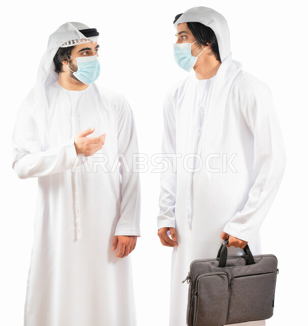 بورتريه لرجلان أعمال عربيان خليجيان اماراتيان يرتديان الكمامة، اتفاق عمل بين رجال الاعمال، التعاون في العمل، نقاشات وحوارات عمل، متابعة العمل، بيئة العمل الاماراتي، الإشراف وتدقيق العمل، الالتزام باجراءات الوقاية من فايروس كورونا، خلفية بيضاء