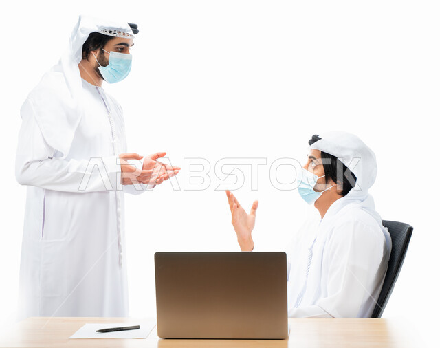 بورتريه لرجلان أعمال عربيان خليجيان اماراتيان يرتديان الكمامة الواقية، انجاز مهام العمل من خلال الحاسوب المحمول، نقاشات وحوارات عمل، متابعة العمل، بيئة العمل الاماراتي، الإشراف وتدقيق العمل، الالتزام باجراءات الوقاية من فايروس كورونا، خلفية بيضاء