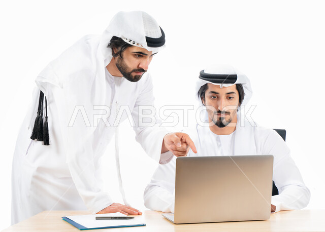 بورتريه لرجلان أعمال عربيان خليجيان اماراتيان في مقر العمل، انجاز مهام العمل من خلال الحاسوب المحمول، نقاشات وحوارات عمل، بيئة العمل الاماراتي، الاشراف وتدقيق العمل، خلفية بيضاء