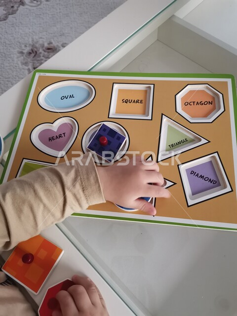 صورة مقربة لطفل صغير يلعب بالألعاب الترفيهية ، ألعاب تعليمية ترفيهية ، تنمية قدرات و مهارات الطفل ، روضة أطفال ، حضانة أطفال ، أنشطة فنية وترفيهية  ، مراكز التنمية الفكرية