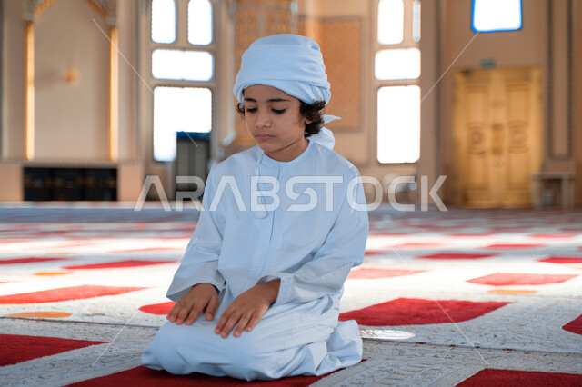 ولد صغير عربي خليجي إماراتي في أحد المساجد العربية، أداء فريضة الصلاة ، العبادة والتقرب الى الله ، أماكن إسلامية مقدسة ، مفهوم أركان الإسلام