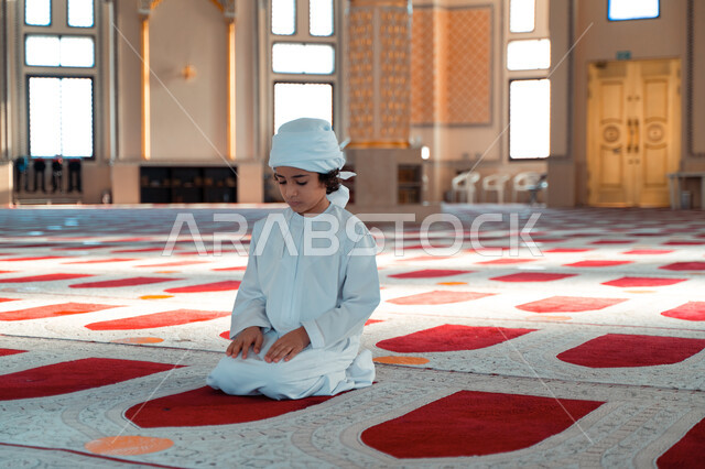 ولد صغير عربي خليجي إماراتي في أحد المساجد العربية، أداء فريضة الصلاة ، العبادة والتقرب الى الله ، أماكن إسلامية مقدسة ، مفهوم أركان الإسلام
