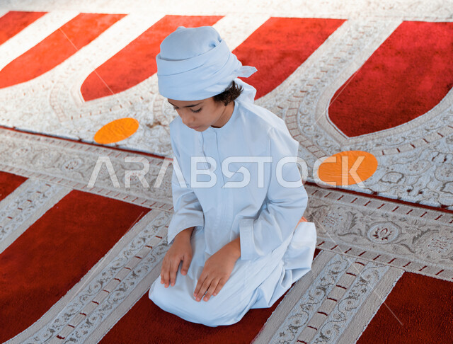 ولد صغير عربي خليجي إماراتي في أحد المساجد العربية، أداء فريضة الصلاة ، العبادة والتقرب الى الله ، أماكن إسلامية مقدسة ، مفهوم أركان الإسلام