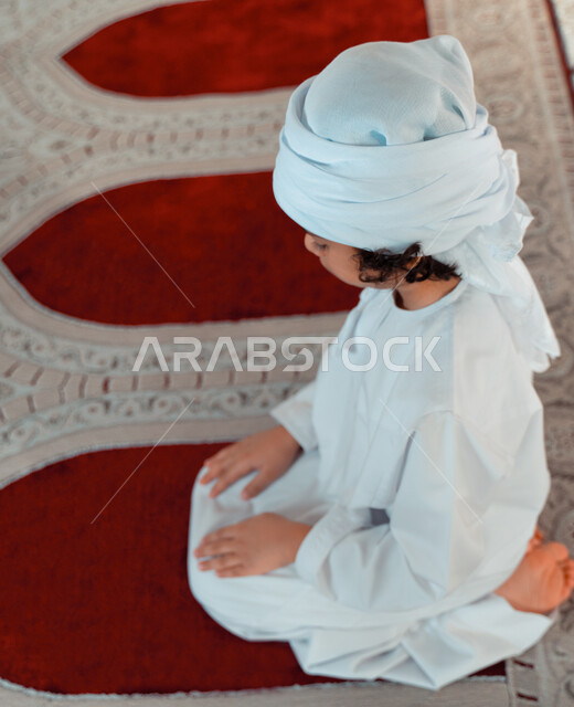 ولد صغير عربي خليجي إماراتي في أحد المساجد العربية، أداء فريضة الصلاة ، العبادة والتقرب الى الله ، أماكن إسلامية مقدسة ، مفهوم أركان الإسلام