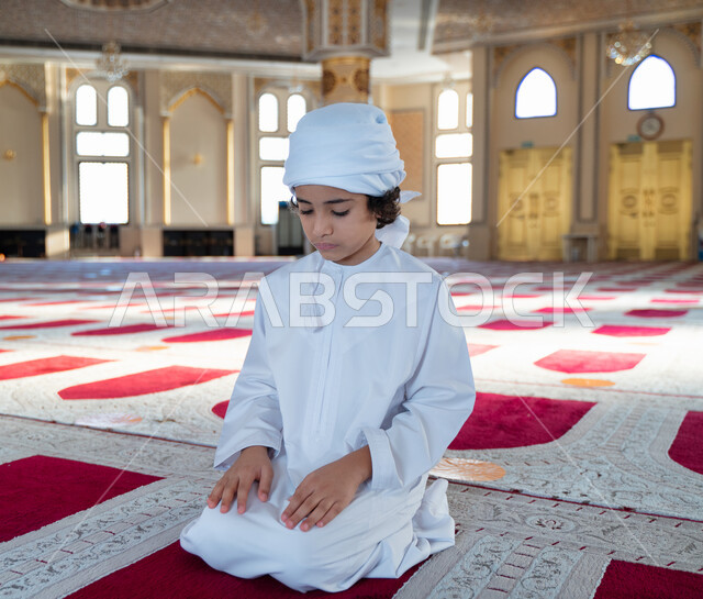 ولد صغير عربي خليجي إماراتي في أحد المساجد العربية، أداء فريضة الصلاة ، العبادة والتقرب الى الله ، أماكن إسلامية مقدسة ، مفهوم أركان الإسلام