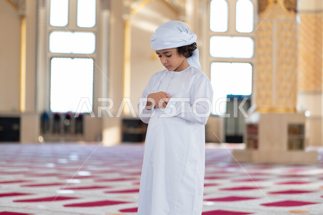 ولد صغير عربي خليجي إماراتي في أحد المساجد العربية، أداء فريضة الصلاة ، العبادة والتقرب الى الله ، أماكن إسلامية مقدسة ، مفهوم أركان الإسلام