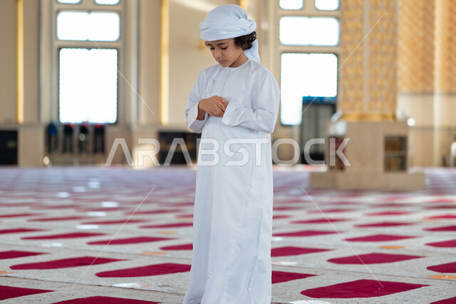 ولد صغير عربي خليجي إماراتي في أحد المساجد العربية، أداء فريضة الصلاة ، العبادة والتقرب الى الله ، أماكن إسلامية مقدسة ، مفهوم أركان الإسلام