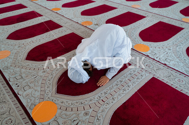 ولد صغير عربي خليجي إماراتي في أحد المساجد العربية، أداء فريضة الصلاة ، السجود في الصلاة ، العبادة والتقرب الى الله ، أماكن إسلامية مقدسة ، مفهوم أركان الإسلام ، إسلاميات وعبادة