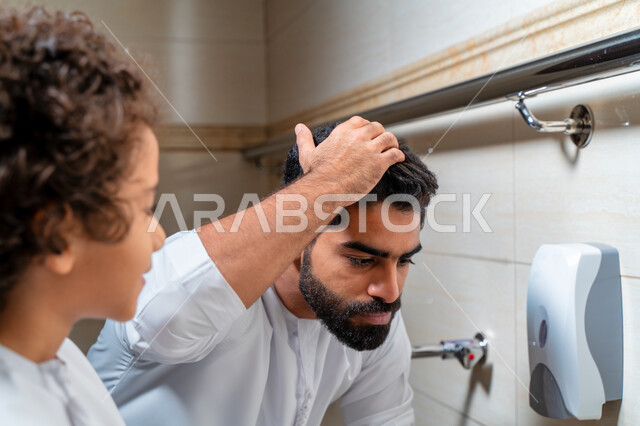 رجل عربي خليجي إماراتي وإبنه في أماكن مخصصة للوضوء في أحد المساجد العربية ، تعلم كيفية الوضوء للأطفال ، الطهارة والوضوء ، مغاسل الوضوء ، أحواض ومغاسل مخصصة للوضوء ، مفهوم أركان الوضوء