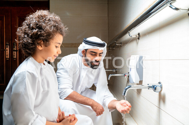 رجل عربي خليجي إماراتي وإبنه في أماكن مخصصة للوضوء في أحد المساجد العربية ، تعلم كيفية الوضوء للأطفال ، الطهارة والوضوء ، مغاسل الوضوء ، أحواض ومغاسل مخصصة للوضوء ، مفهوم أركان الوضوء