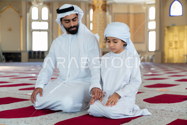 رجل عربي خليجي إماراتي وإبنه في أحد المساجد العربية، تعليم أداء فريضة الصلاة، تعليم الصلاة للأطفال، العبادة والتقرب الى الله، أماكن إسلامية مقدسة، مفهوم أركان الإسلام، إسلاميات وعبادة