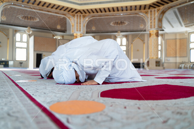 An Emirati Arab Gulf man and his son in an Arab mosque, performing the obligatory prayer, prostrating in prayer, teaching prayer to children, worship and drawing closer to God, Islamic holy places, the concept of the pillars of Islam, Islamism and worship