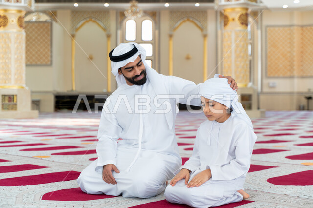 رجل عربي خليجي إماراتي وإبنه في أحد المساجد العربية، تعليم أداء فريضة الصلاة، تعليم الصلاة للأطفال، العبادة والتقرب الى الله، أماكن إسلامية مقدسة، مفهوم أركان الإسلام، إسلاميات وعبادة