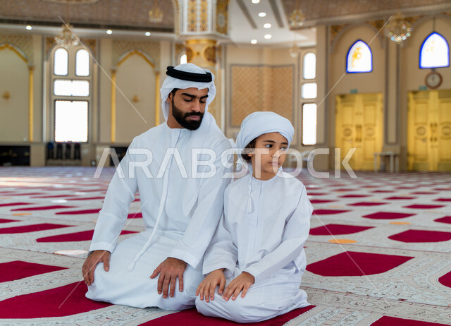 رجل عربي خليجي إماراتي وإبنه في أحد المساجد العربية، أداء فريضة الصلاة، تعليم الصلاة للأطفال، العبادة والتقرب الى الله، أماكن إسلامية مقدسة، مفهوم أركان الإسلام، إسلاميات وعبادة