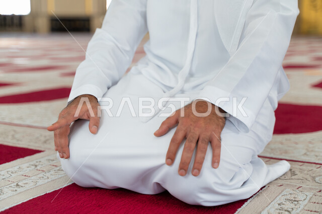 صورة مقربة لرجل عربي خليجي إماراتي في أحد المساجد العربية ، أداء فريضة الصلاة ، التشهد في الصلاة ، العبادة والتقرب الى الله ، أماكن إسلامية مقدسة ، إسلاميات وعبادة