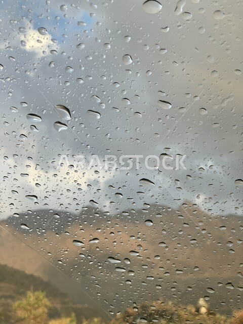 Water drops on a glass window, rainy atmosphere, glass background with dew drops, winter atmosphere, heavy rain, scenic beauty, nature background