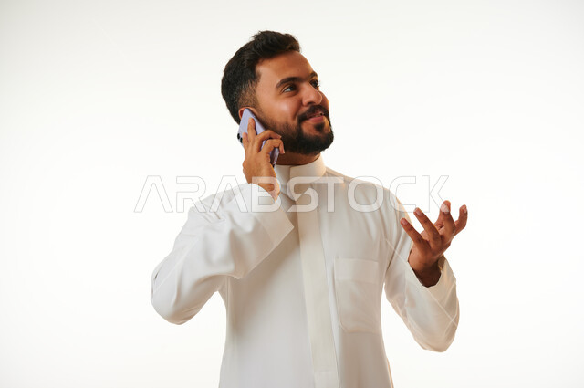 بورتريه لشاب عربي خليجي سعودي يقوم بإجراء مكالمة هاتفية، التواصل مع الأفراد، اتصال وتواصل، علاقات اجتماعية، دردشة وتعارف، التواصل الإجتماعي، خلفية بيضاء