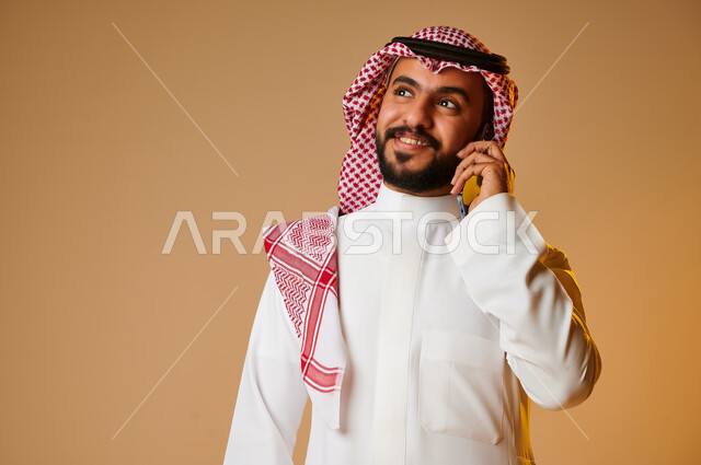 بورتريه لشاب عربي خليجي سعودي يقوم بإجراء مكالمة هاتفية، التواصل مع الأفراد، اتصال وتواصل، علاقات اجتماعية، دردشة وتعارف، التواصل الإجتماعي، خلفية ملونة