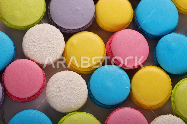A close-up of a group of colored macarons filled with cream, sweets and sugars, cookies, candy pieces, dessert, delicious cold sweets