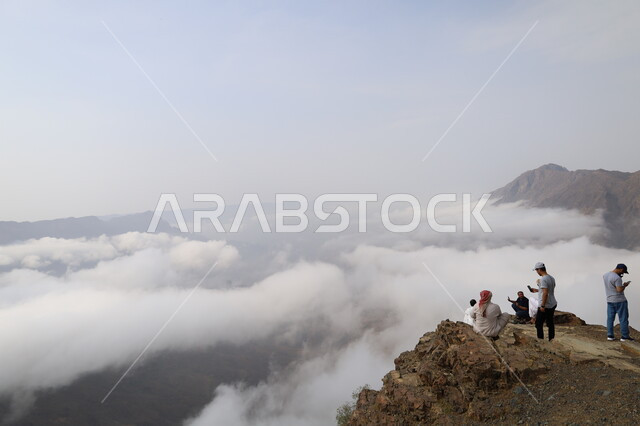 مجموعة من السياح فوق جبال الباحة في المملكة العربية السعودية ، السحب البيضاء في سماء السعودية، المرتفعات الجبلية، مناظر طبيعية خلابة، السحب البيضاء فوق جبال الباحة