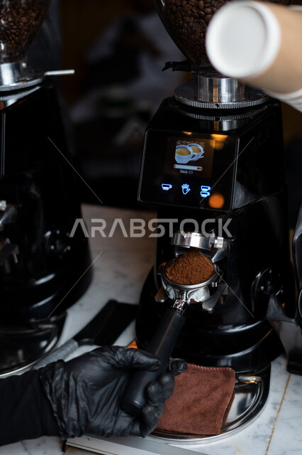 صورة مقربة لرجل يقوم بتحضير القهوة، آلة القهوة، استخدام ذراع ماكينة الاسبريسو، اعداد كوب قهوة الاسبريسو، صنع القهوة اللذيذة، المشروبات الساخنة