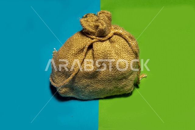 صورة مقربة لكيس الخيش، مفهوم الدقة والزكاة، قماش الخيش، كيس محكم الاغلاق، قماش خشن، خلفية ملونة