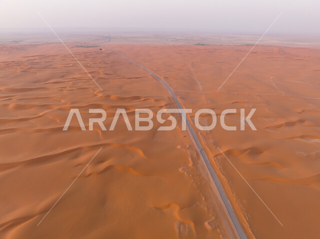 Aerial photo from above of the highway in the middle of the desert, desert road, asphalt highway between sand dunes, desert environment, sand dunes, sand hills