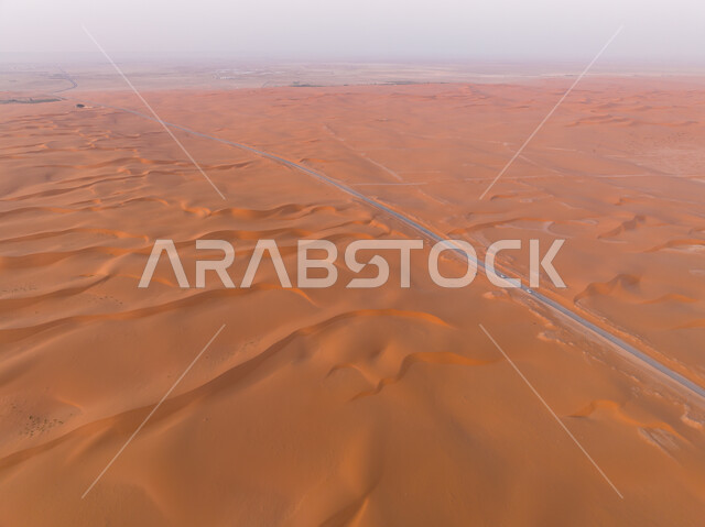 Aerial photo from above of the highway in the middle of the desert, desert road, asphalt highway between sand dunes, desert environment, sand dunes, sand hills