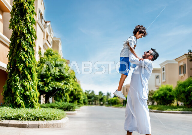 Enjoying the times playing with the children during the summer vacation, gestures indicating joy and happiness, a man and his son, two Saudi Arabs from the Gulf, in high-end residential neighborhoods and villas in Saudi Arabia, a residential compound, rec