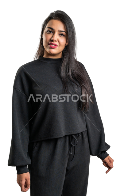 Portrait of a smiling Saudi Arabian Gulf woman looking at the camera with facial gestures indicating happiness, wearing casual black clothes, taking care