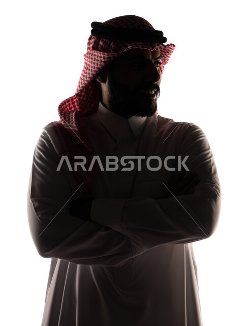 بورتريه ، صورة ظلية لرجل عربي خليجي سعودي ، يرتدي الزي السعودي التقليدي ، بأيدي متقاطعة ، ينظر إلى الكاميرا ، خلفية بيضاء
