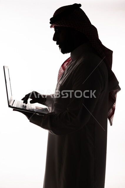بورتريه ، صورة ظلية لرجل عربي خليجي سعودي ، إستخدام جهاز الحاسوب المحمول ، تصفح الإنترنت ، إستخدام اجهزة تقنية حديثة ، العمل عن بعد ، التسويق الإلكتروني ، مهن ووظائف ، خلفية بيضاء