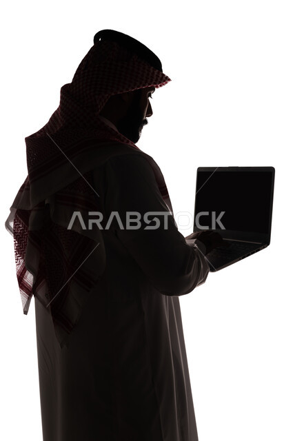 بورتريه ، صورة ظلية لرجل عربي خليجي سعودي ، إستخدام جهاز الحاسوب المحمول ، تصفح الإنترنت ، إستخدام اجهزة تقنية حديثة ، العمل عن بعد ، التسويق الإلكتروني ، مهن ووظائف ، خلفية بيضاء
