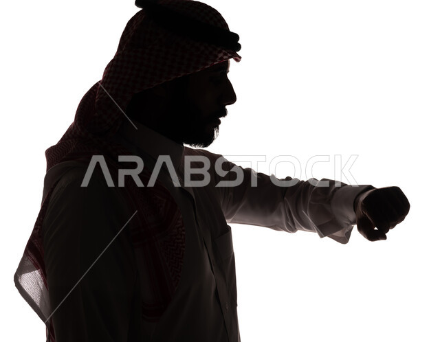 بورتريه ، صورة ظلية لرجل عربي خليجي سعودي ، ينظر ليده ، إنتظار شيء ما ، خلفية بيضاء