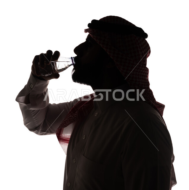 بورتريه ، صورة ظلية لرجل عربي خليجي سعودي ، يقوم بشرب الماء ، مفهوم الصحة ، المحافظة على صحة الجسم ، خلفية بيضاء