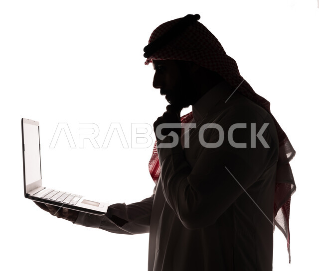 بورتريه ، صورة ظلية لرجل عربي خليجي سعودي ، إستخدام جهاز الحاسوب المحمول ، إيماءات تدل على التفكير ، تصفح الإنترنت ، إستخدام اجهزة تقنية حديثة ، العمل عن بعد ، التسويق الإلكتروني ، مهن ووظائف ، عقد إجتماع عمل عبر اللابتوب ، خلفية بيضاء