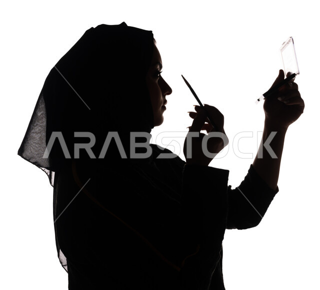 بورتريه ، صورة ظلية لمرأة عربية خليجية سعودية ، إستخدام إحدى أدوات التجميل ( فرشاة ظل العيون ) ، التسويق لمنتجات التجميل ، الإهتمام بالجمال والمظهر الخارجي ، أدوات مكياج تتوريال ، خلفية بيضاء