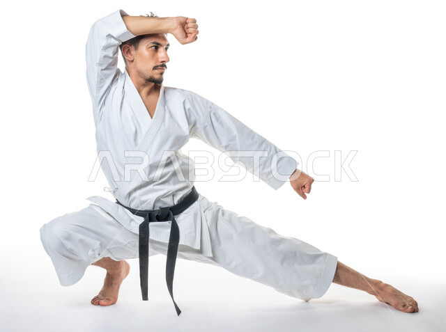 Martial arts, portrait of a Saudi Arabian Gulf man practicing Japanese karate, applying kata movements, white karate uniform with black belt, training in special combat movements, Japanese martial arts, full-length body image, white background