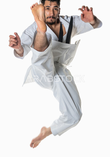 Portrait of a Saudi Arabian Gulf man practicing Japanese karate, white karate uniform with black belt, training in special martial arts, martial arts, karate tournaments, full-length body image, white background