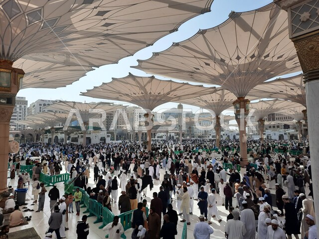 تجمع المسلمون في المجمع الخارجي للمسجد النبوي في المدينة المنورة بالمملكة العربية السعودية، ساحة المسجد النبوي الشريف، الحرم النبوي الشريف، أماكن إسلامية مقدسة، المظلات الالكترونية، معالم دينية إسلامية