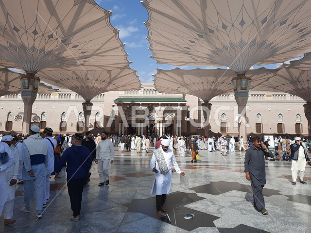 تجمع المسلمون في المجمع الخارجي للمسجد النبوي في المدينة المنورة بالمملكة العربية السعودية، ساحة المسجد النبوي الشريف، الحرم النبوي الشريف، أماكن إسلامية مقدسة، المظلات الالكترونية، معالم دينية إسلامية