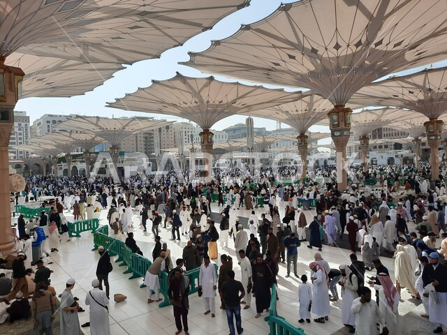 Muslims gathered in the outer complex of the Prophet’s Mosque in Madinah, Kingdom of Saudi Arabia, the square of the Prophet’s Mosque, the Prophet’s Noble Sanctuary, Islamic holy places, electronic umbrellas, Islamic religious landmarks