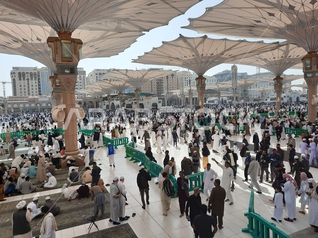 تجمع المسلمون في المجمع الخارجي للمسجد النبوي في المدينة المنورة بالمملكة العربية السعودية، ساحة المسجد النبوي الشريف، الحرم النبوي الشريف، أماكن إسلامية مقدسة، المظلات الالكترونية، معالم دينية إسلامية